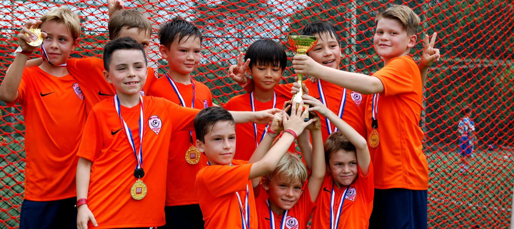BFA players celebrating with medals and a trophy